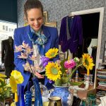 kvinne som danderer blomster inne på et loppemarked