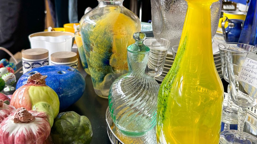 En sjarmerende utstilling av fargerike glassvaser og dekorative keramiske grønnsaker pryder bordet som er merket, og tilbyr et herlig utvalg av former og teksturer.