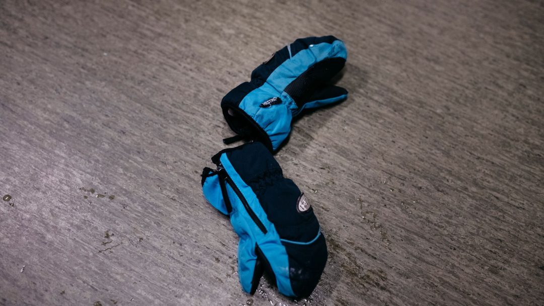 Et par blå og svarte hansker hviler på et vått, grått gulv, og gjenspeiler subtilt de dystre funnene fra en klimasårbarhetsanalysen.