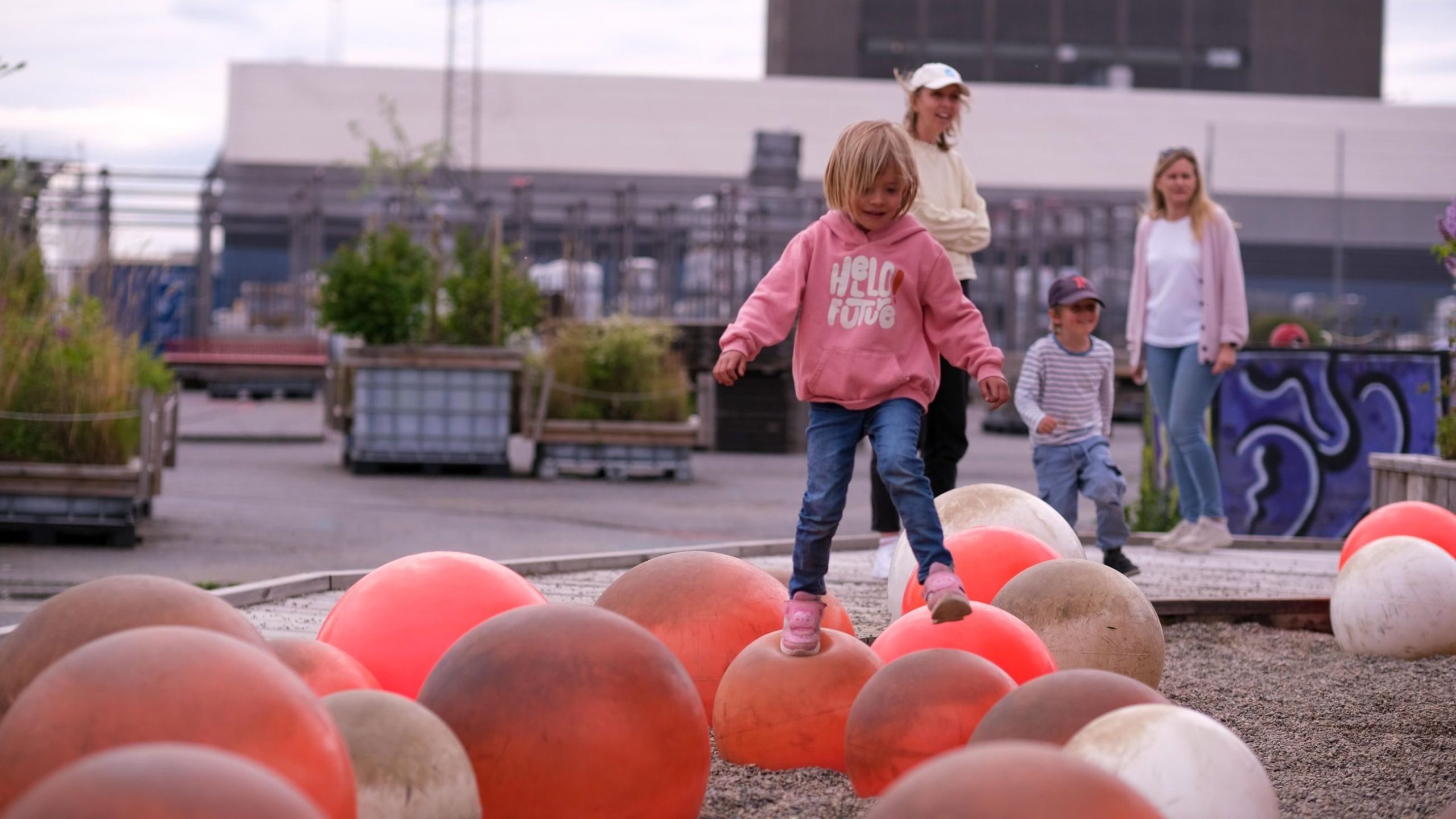Kirsten balanserer på noen baller som sitter fast i bakken, ,minner litt om livbøyer man ser ute på sjøen.