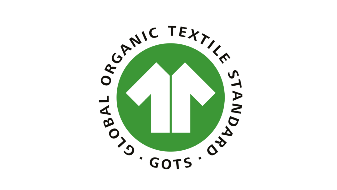 GOTS-logo: Grønn sirkel med to hvite piler som peker opp. Teksten lyder Global Organic Textile Standard.