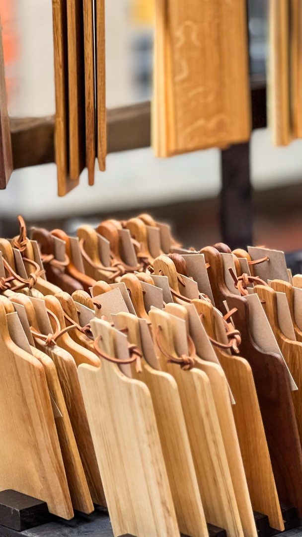 Skjærebrett av tre vises i rekker, stående oppreist med skinnløkker, og inviterer deg på skattejakteventyr gjennom markedsbodsskattene.