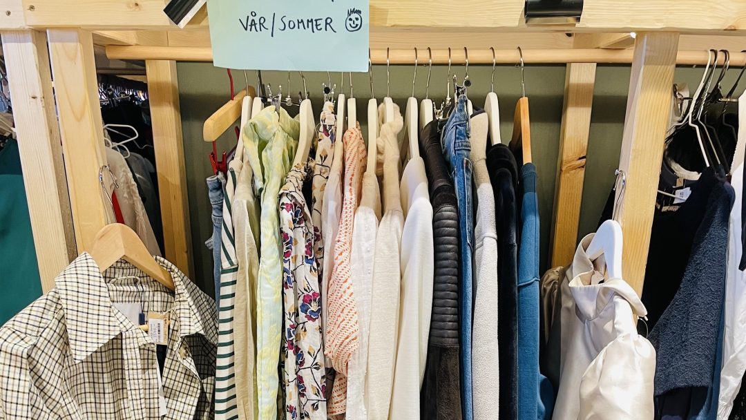 Stativ med vår- og sommerklær i størrelsene Small, XS og 36, inkludert skjorter, bluser og jakker hentet fra bruktbutikker.