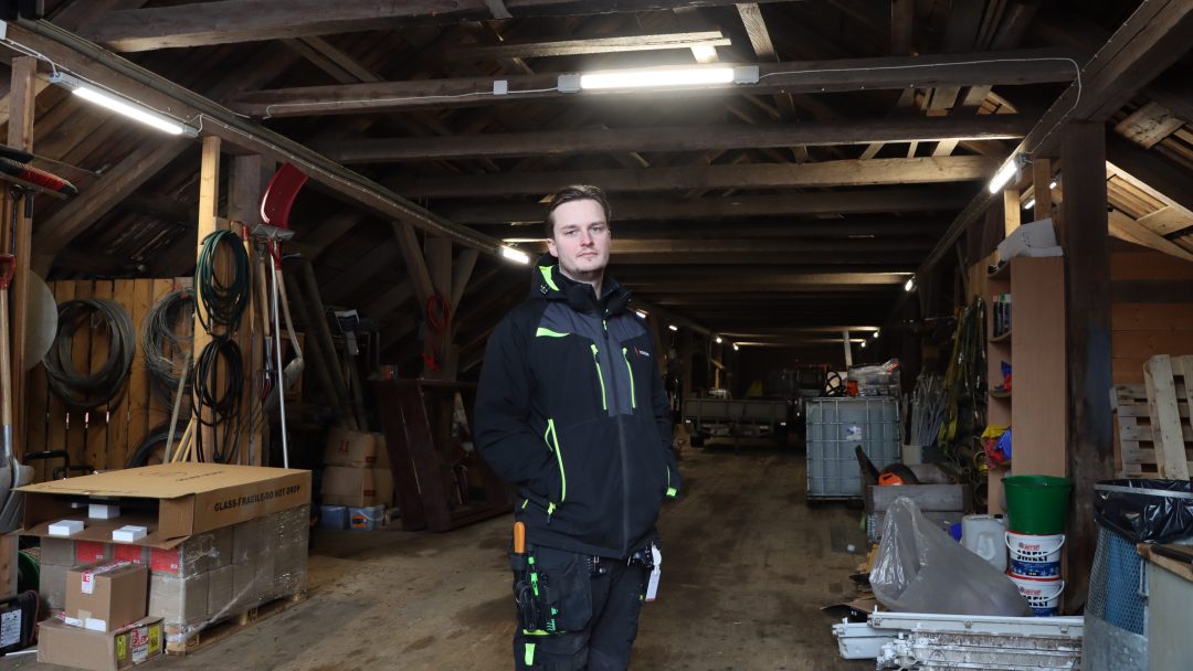 electrician Tobias Bondevik is replacing halogen lights with energy-efficient LEDs in a barn at Bogstad Farm