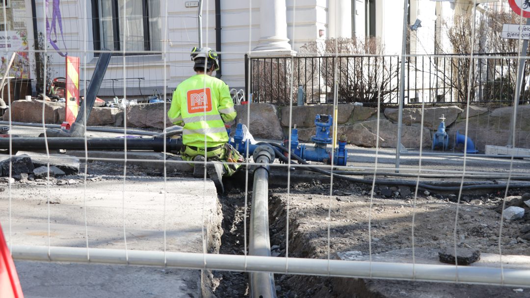 A man in yellow workwear replacing water pipes in Gabels gate. Mann i gult arbeidstøy jobber med å skifte vannrør i Gabels gate