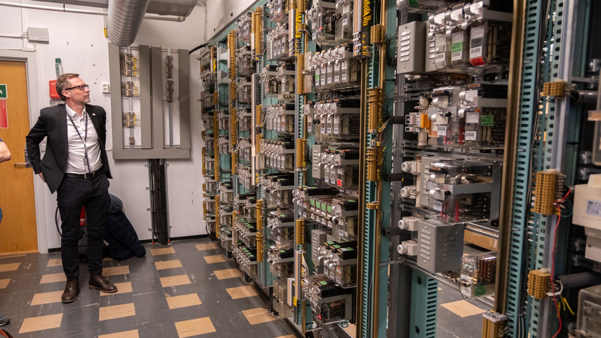 mann foran en vegg med elektronikk - relérommet i Oslos t-bane system