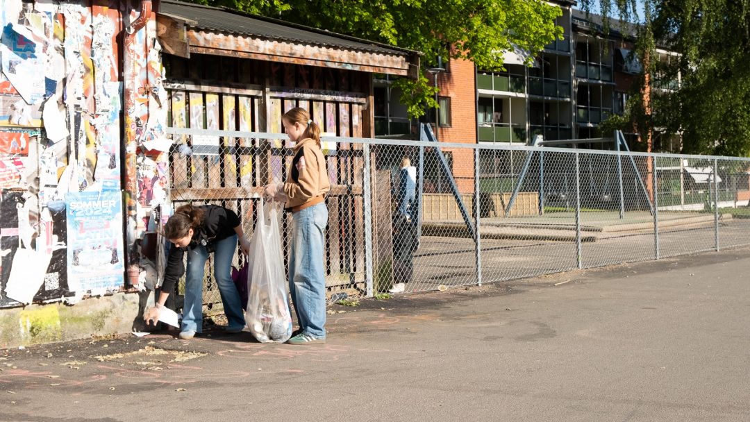 To jenter plukker søppel fra gata på Grunerløkka