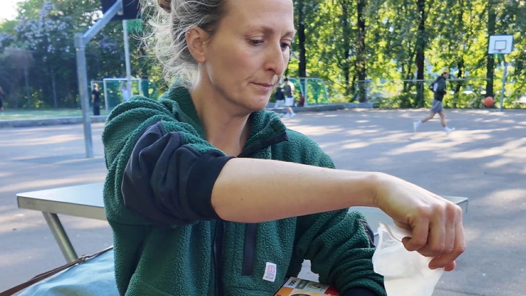 En kvinne putter avfall ned i en pose