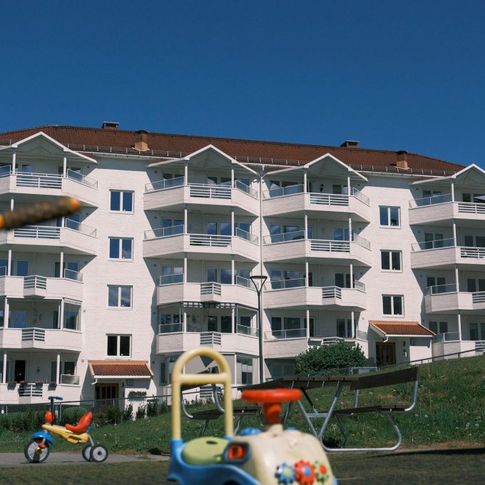 Bilde av en gressplen med en blokk i bakgrunnen