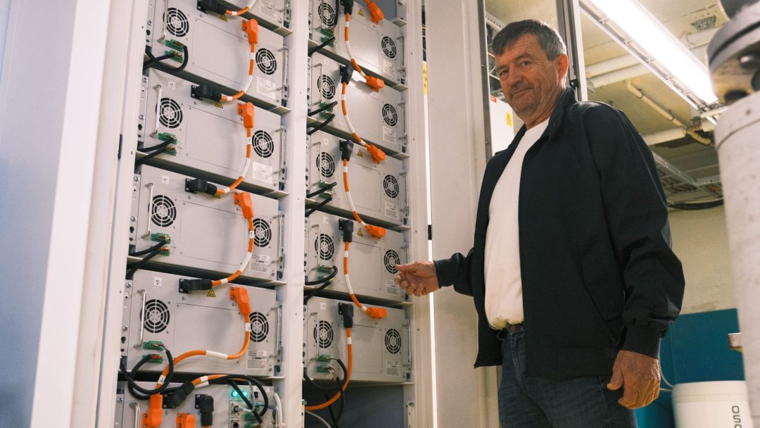 Styremedlem Svein står foran batteriene i det gamle fyrrommet.